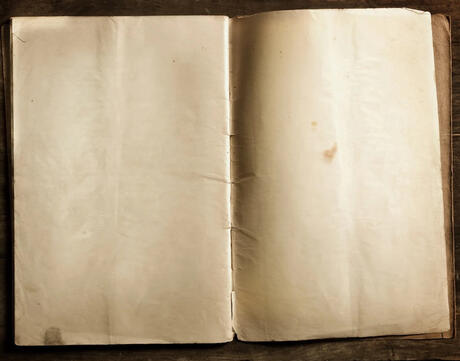 A book with worn blank pages sits open-faced.